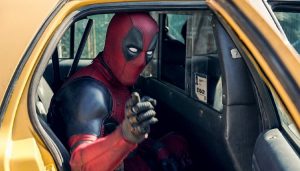 Deadpool getting out of his movei car, a taxi