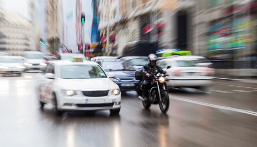 A person riding a motorcycle in the rain shows how dangerous the practice can be