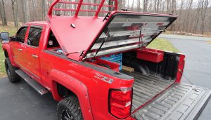 A red truck, sporting various truck accessories.