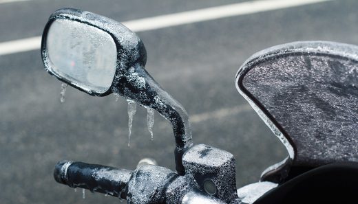 closeup of frozen motorcycle windshield and rear mirror In most of the country, winter means no more riding fun. This is why, what you can do to make it better, and the best motorcycles for winter riding