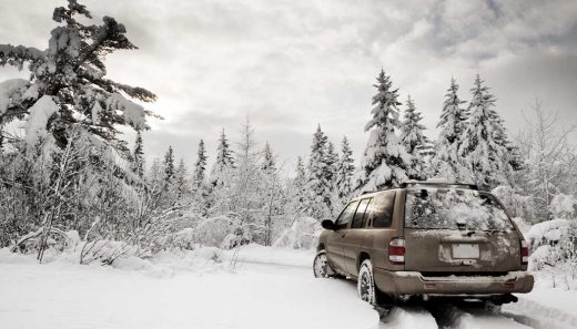 Best vehicles for snow A sedan driving on a snow covered road.