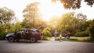 An opened SUV with a family walking near it.